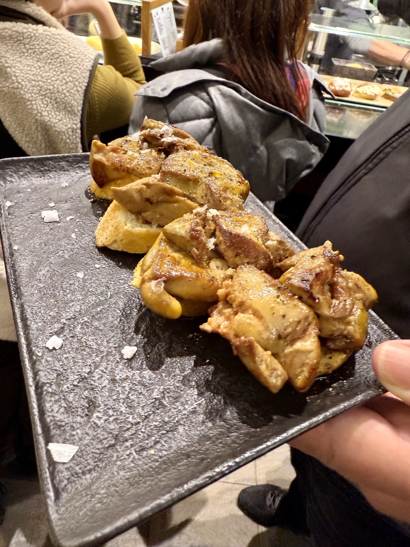 Foie-Gras-Pintxos auf geröstetem Brot in der Bar Sport in Donostia-San Sebastián – frisch gebratene Foie Gras mit grobem Salz serviert an der Theke der Parte Vieja.