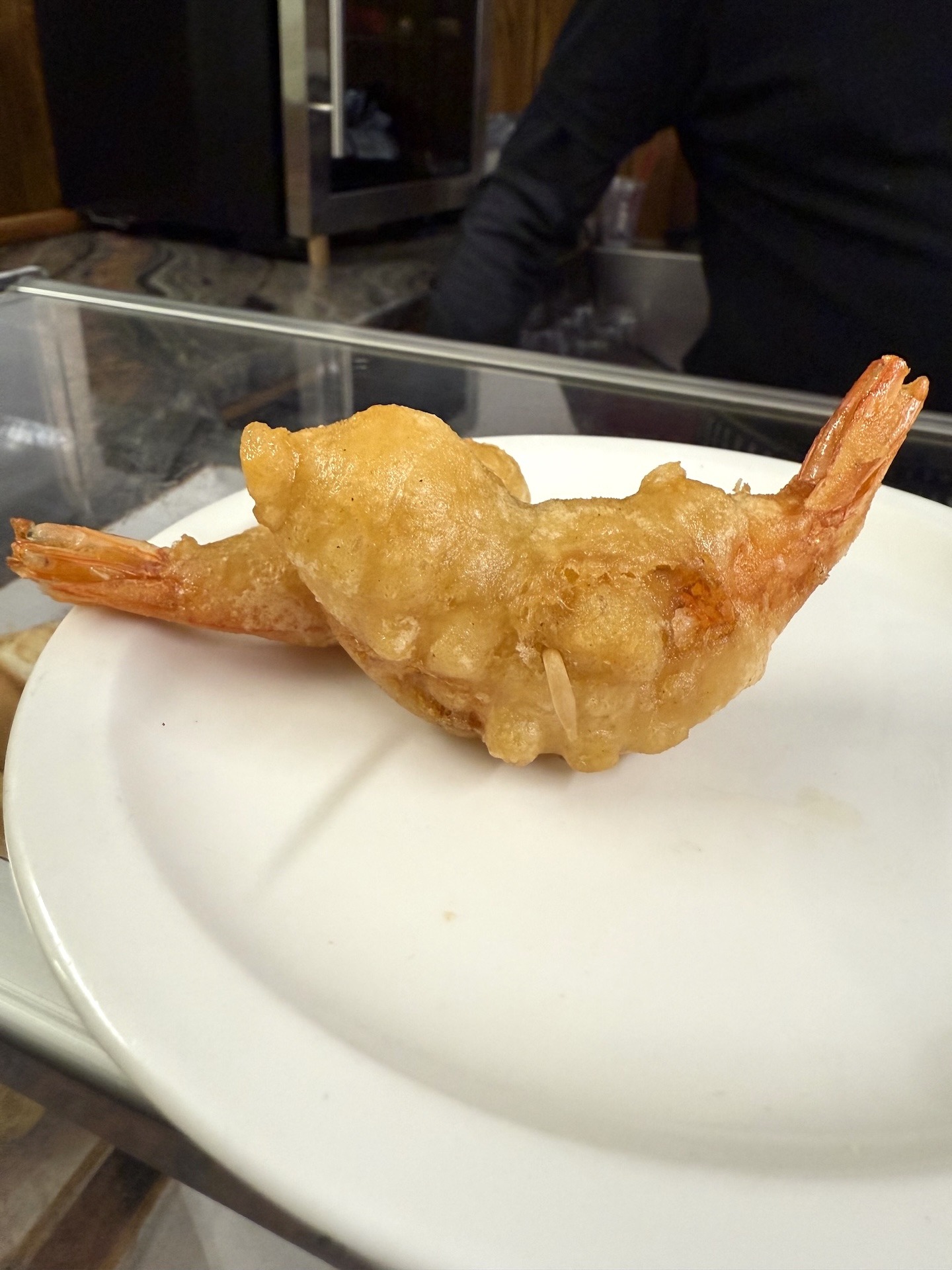 Gambas a la gabardina im Bar Paco Bueno in Donostia-San Sebastián – goldbraun ausgebackene Garnelen im luftigen Teigmantel auf weißem Teller an der Bar serviert.