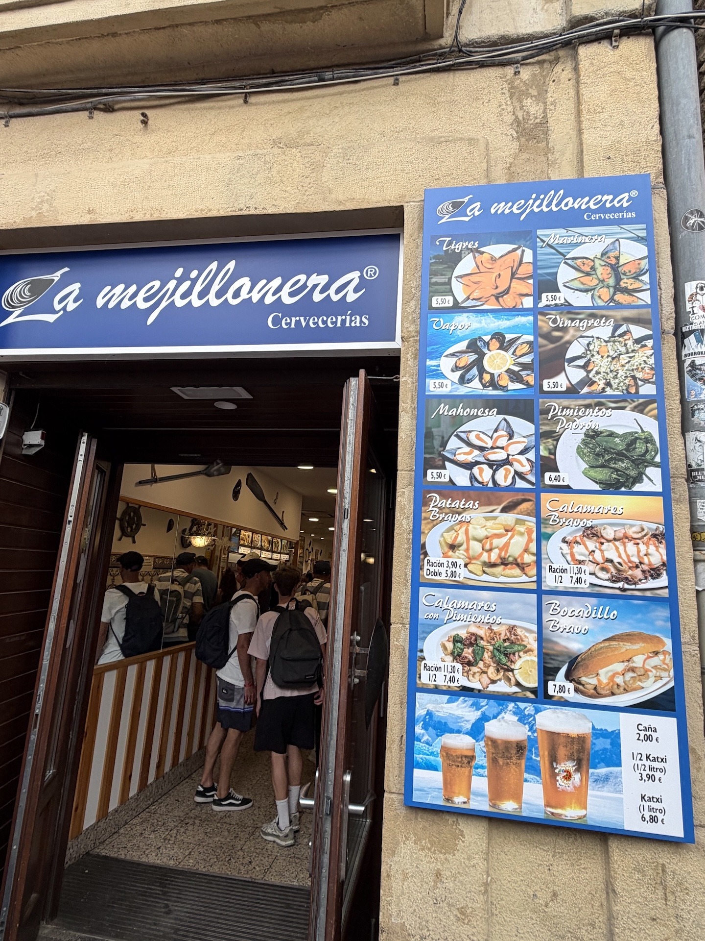 Außenansicht der La Mejillonera in der Parte Vieja von Donostia-San Sebastián mit Speisekarte und Eingang.